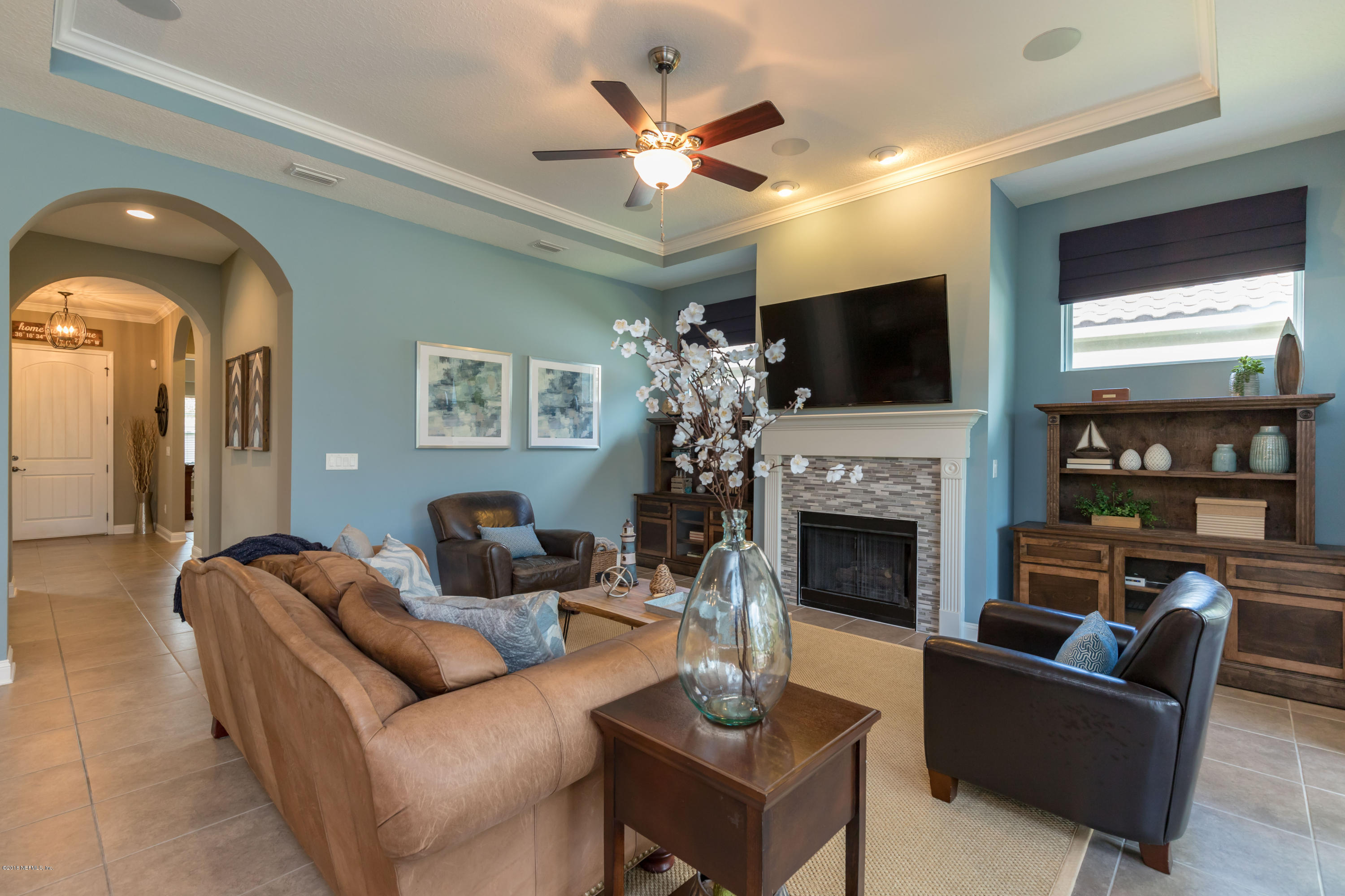 3811 Valverde Circle Jacksonville, FL 32224 - Photo 7 of 42 a living room with furniture a fireplace and a flat screen tv