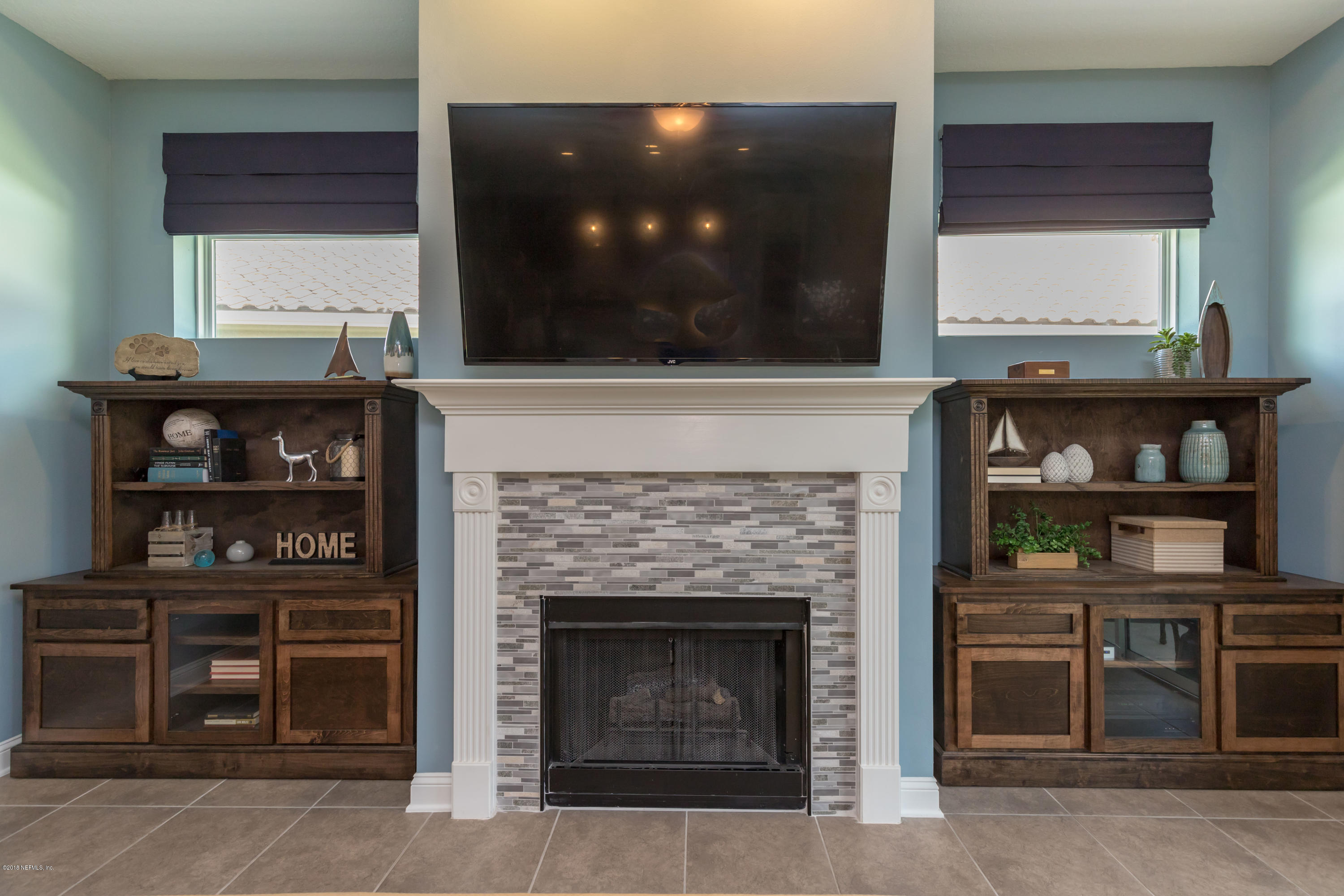 3811 Valverde Circle Jacksonville, FL 32224 - Photo 8 of 42 a living room with a fireplace and a flat screen tv