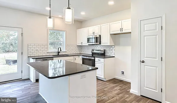 a kitchen with stainless steel appliances granite countertop a sink a stove and a refrigerator