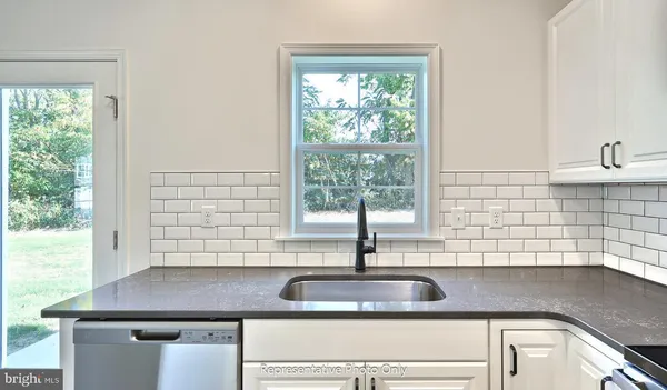 a kitchen with granite countertop a sink and a window