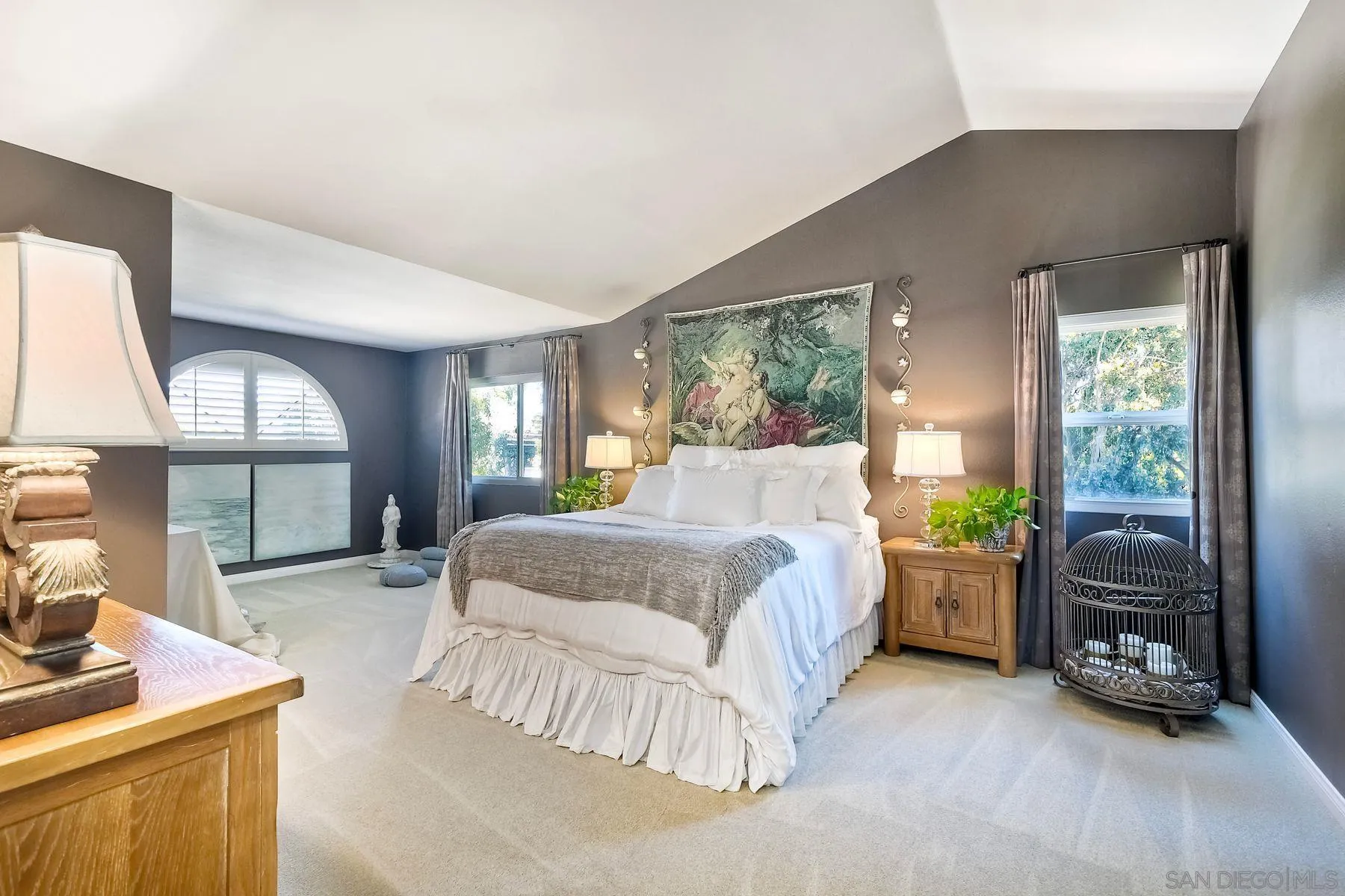 11467 Box Elder Place San Diego, CA 92127 - Photo 17 of 31 a spacious bedroom with a bed a table and large mirror with window