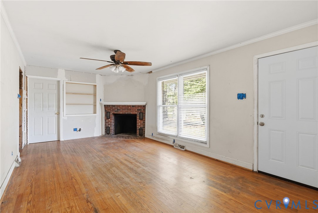 6106 Lewis Road Petersburg, VA 23803 - Photo 5 of 29 a view of an empty room with wooden floor fireplace and a window