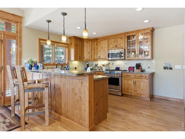a kitchen with stainless steel appliances granite countertop a stove sink and cabinets