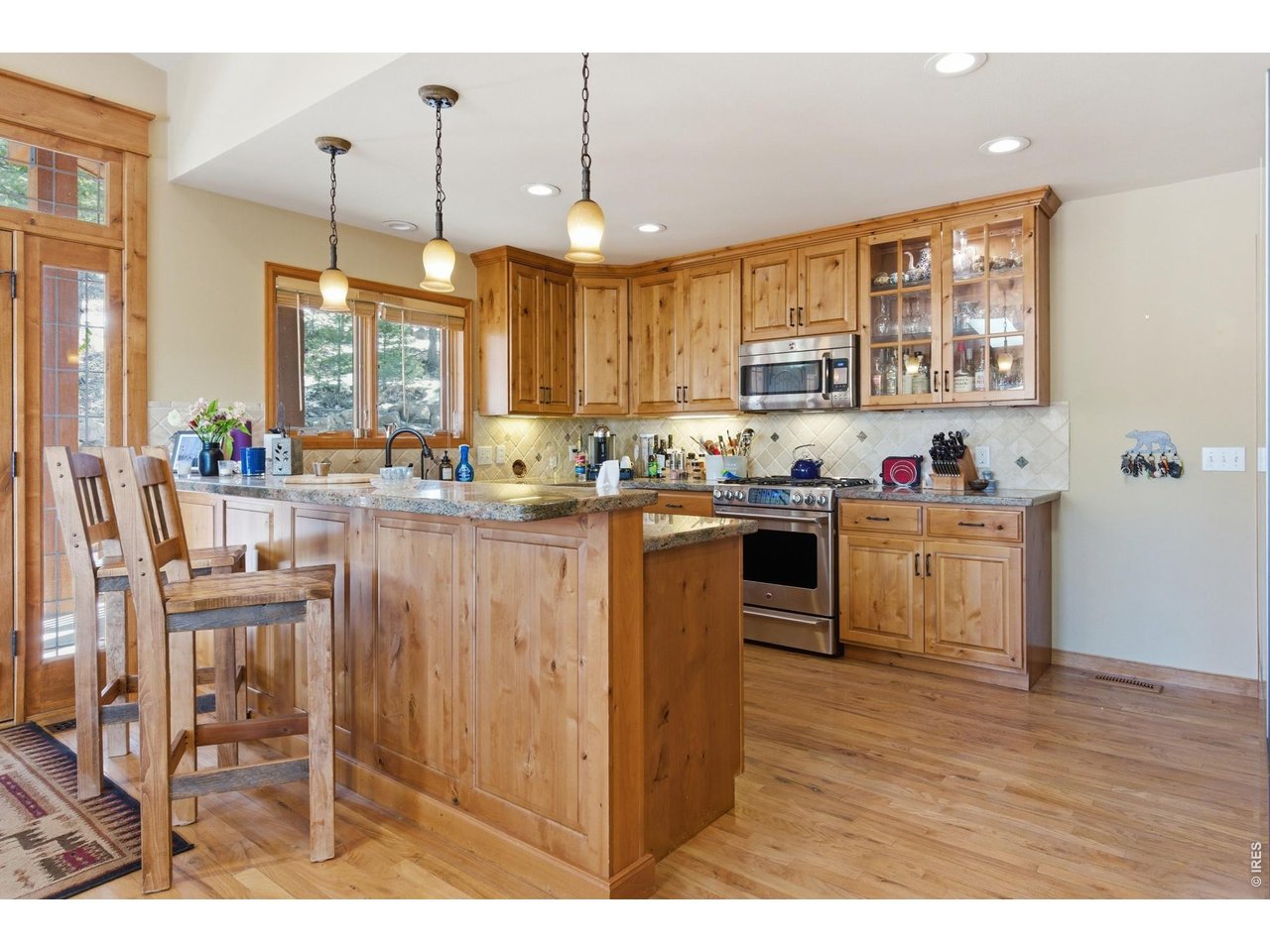 4079 Little Valley Road Estes Park, CO 80517 - Photo 14 of 39 a kitchen with kitchen island granite countertop a sink cabinets and wooden floor