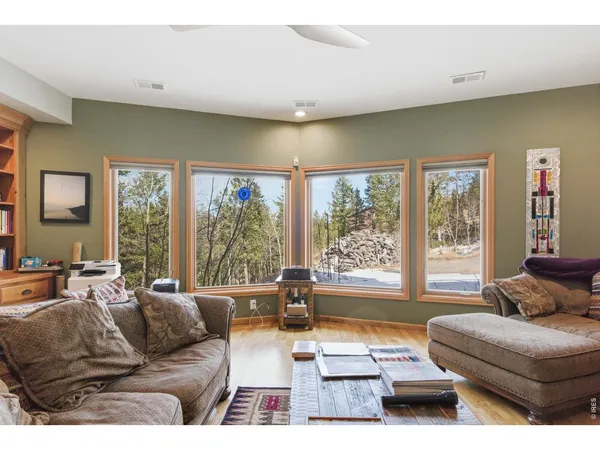 a living room with furniture a large window and bookshelf