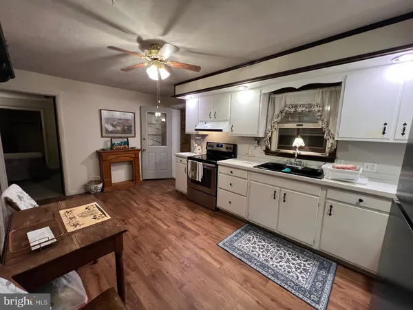 a kitchen with stainless steel appliances kitchen island granite countertop a sink dishwasher stove and refrigerator with wooden floor