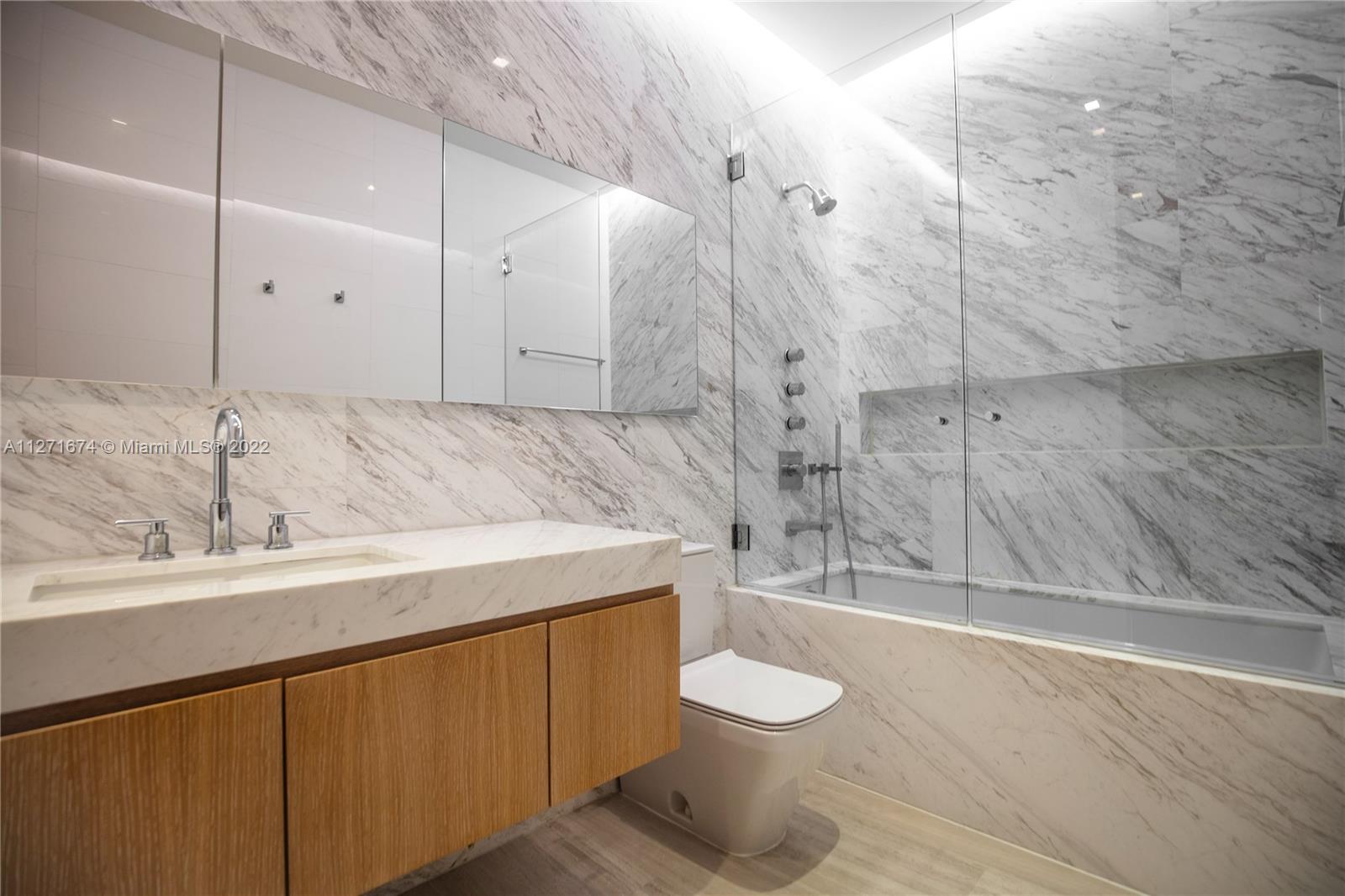 5061 North Bay Road Miami Beach, FL 33140 - Photo 18 of 23 a bathroom with a sink a toilet and shower