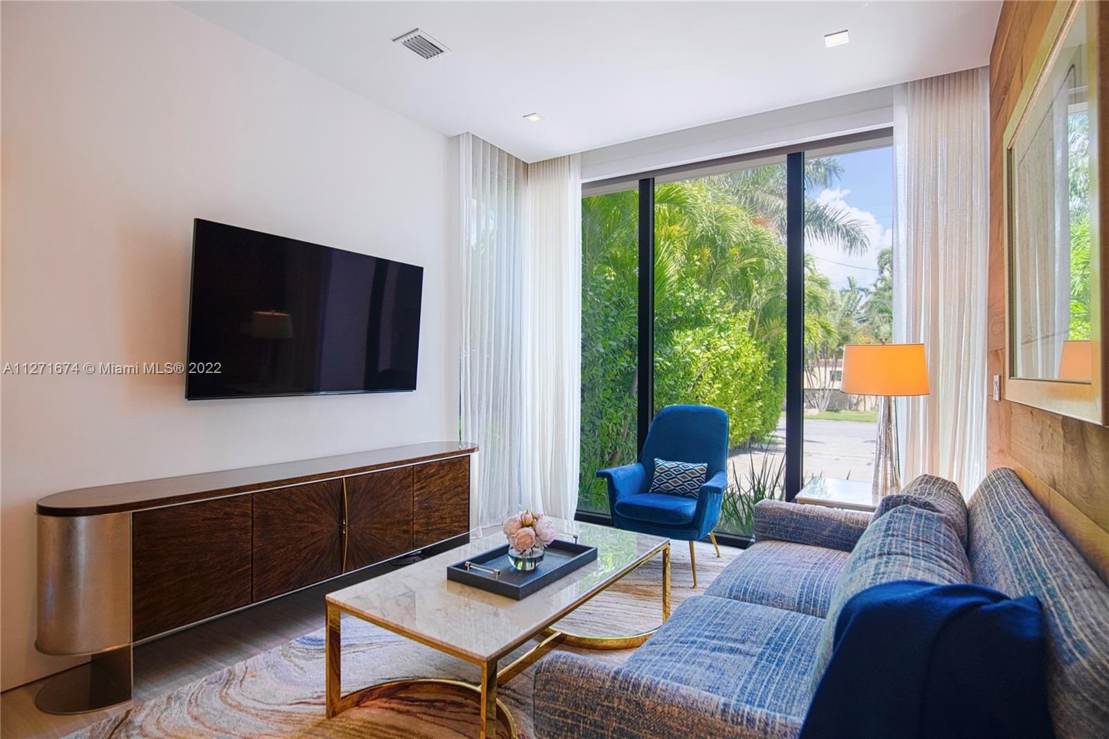 5061 North Bay Road Miami Beach, FL 33140 - Photo 19 of 23 a living room with furniture and a flat screen tv