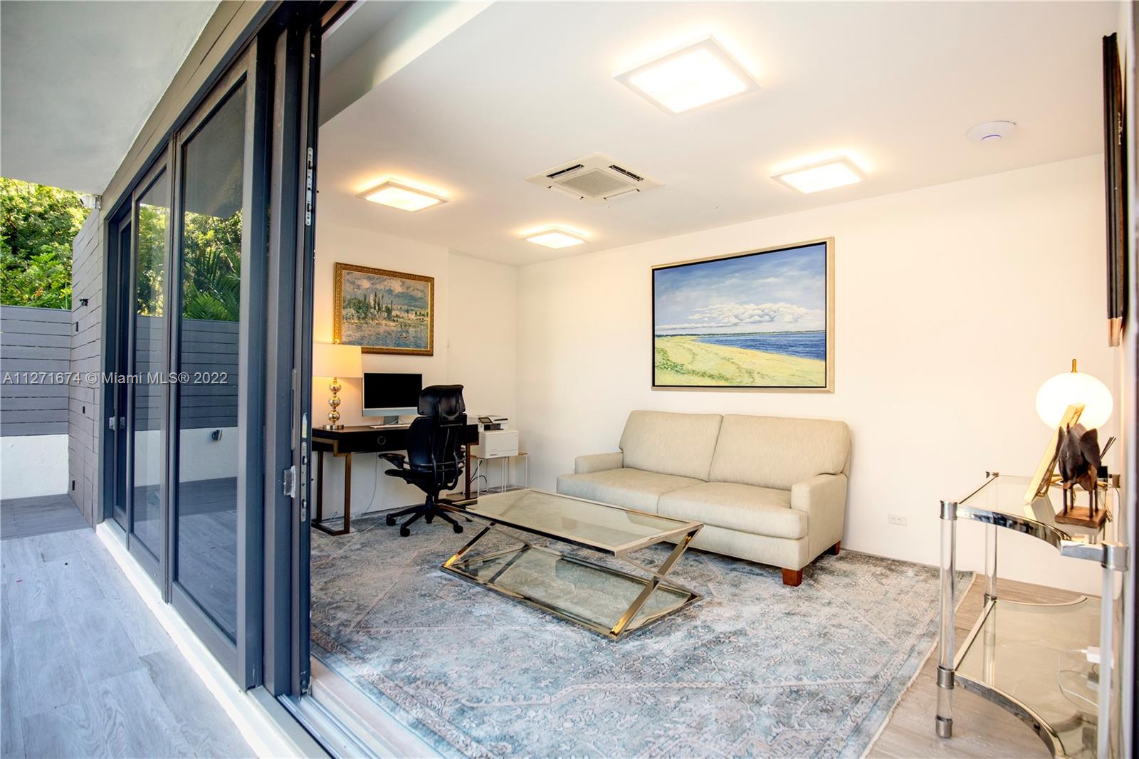 5061 North Bay Road Miami Beach, FL 33140 - Photo 20 of 23 a living room with furniture and a floor to ceiling window