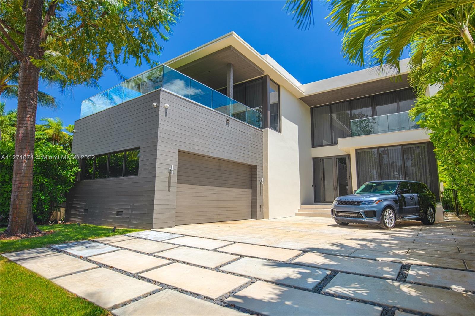 5061 North Bay Road Miami Beach, FL 33140 - Photo 2 of 23 a front view of a house with a garden