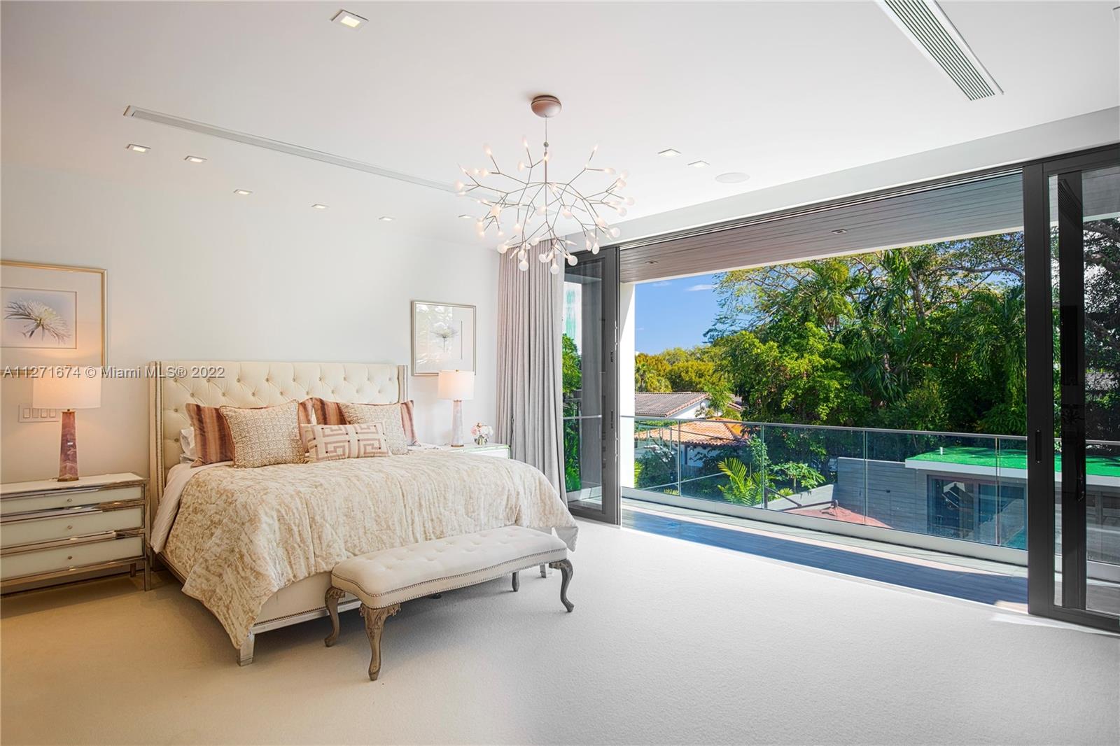 5061 North Bay Road Miami Beach, FL 33140 - Photo 7 of 23 a bedroom with a bed and a chandelier