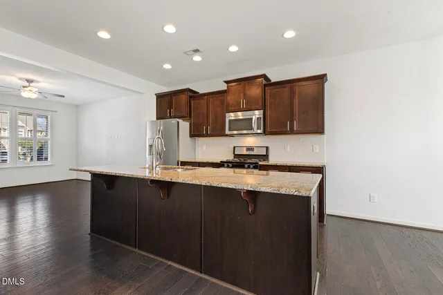 a kitchen with stainless steel appliances granite countertop a sink a stove a microwave a sink and a refrigerator