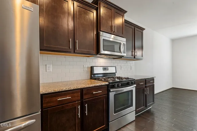 a kitchen with stainless steel appliances granite countertop a stove and a microwave