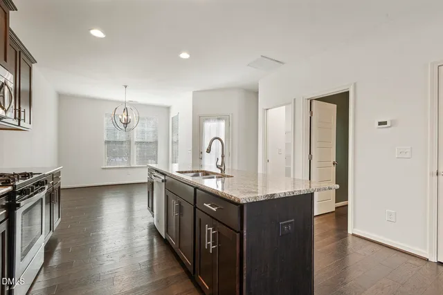 a kitchen with stainless steel appliances granite countertop a sink and wooden cabinets
