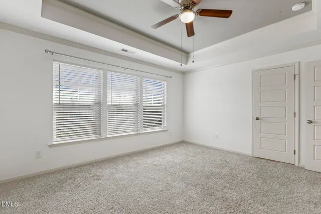 an empty room with chandelier fan