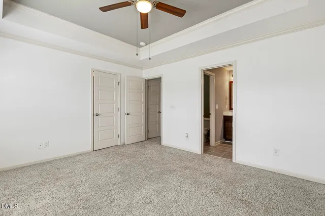 an empty room with closet and a chandelier fan