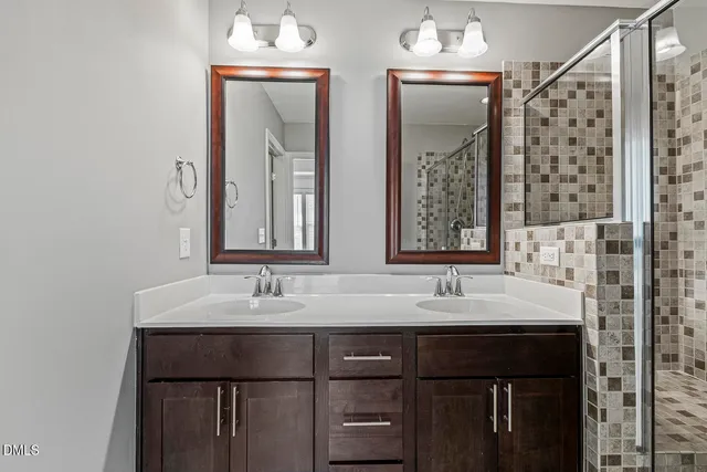 a bathroom with a double sink shower and a mirror