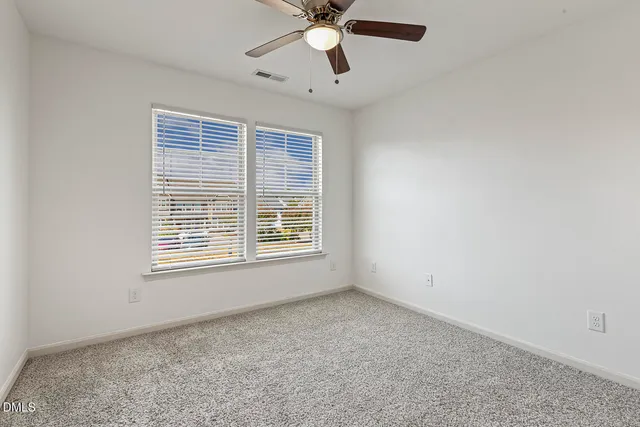 an empty room with chandelier fan