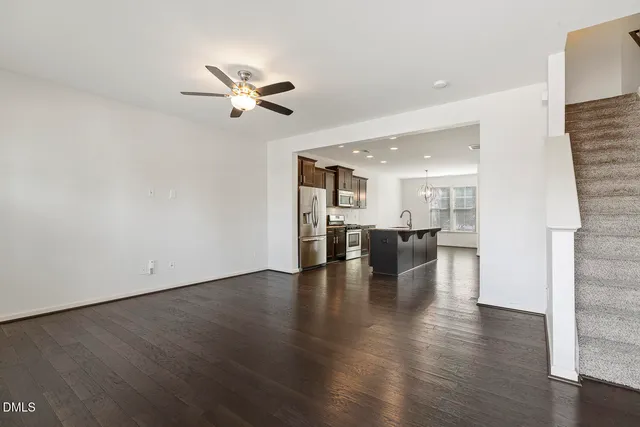 a view of empty room with wooden floor and ceiling fan