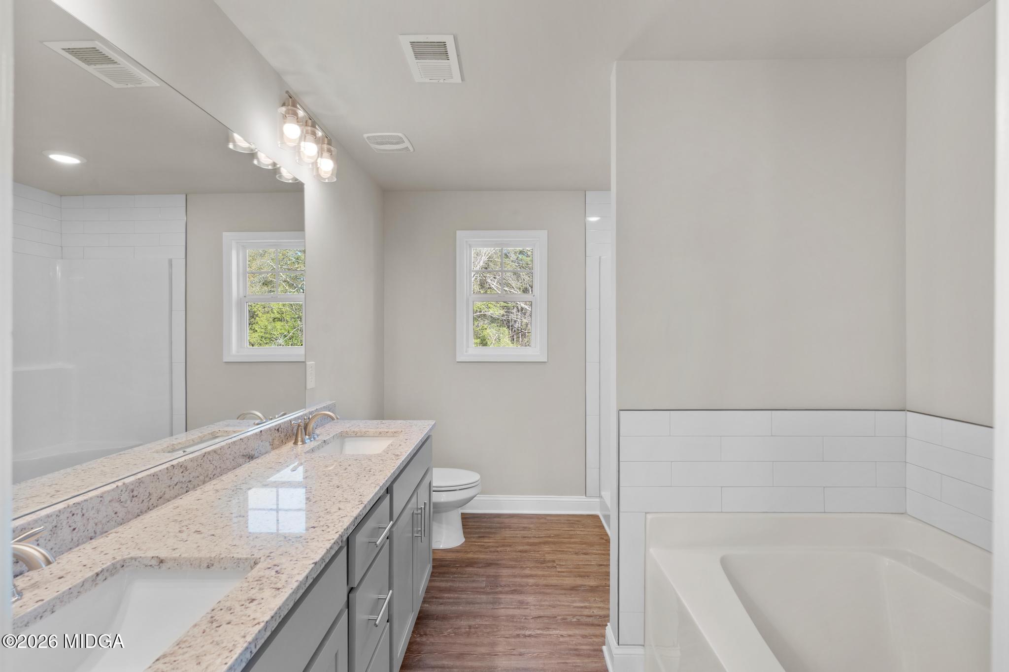 220 Welsh Trail Macon, GA 31216 - Photo 21 of 30 a bathroom with a granite countertop bathtub a sink and a shower