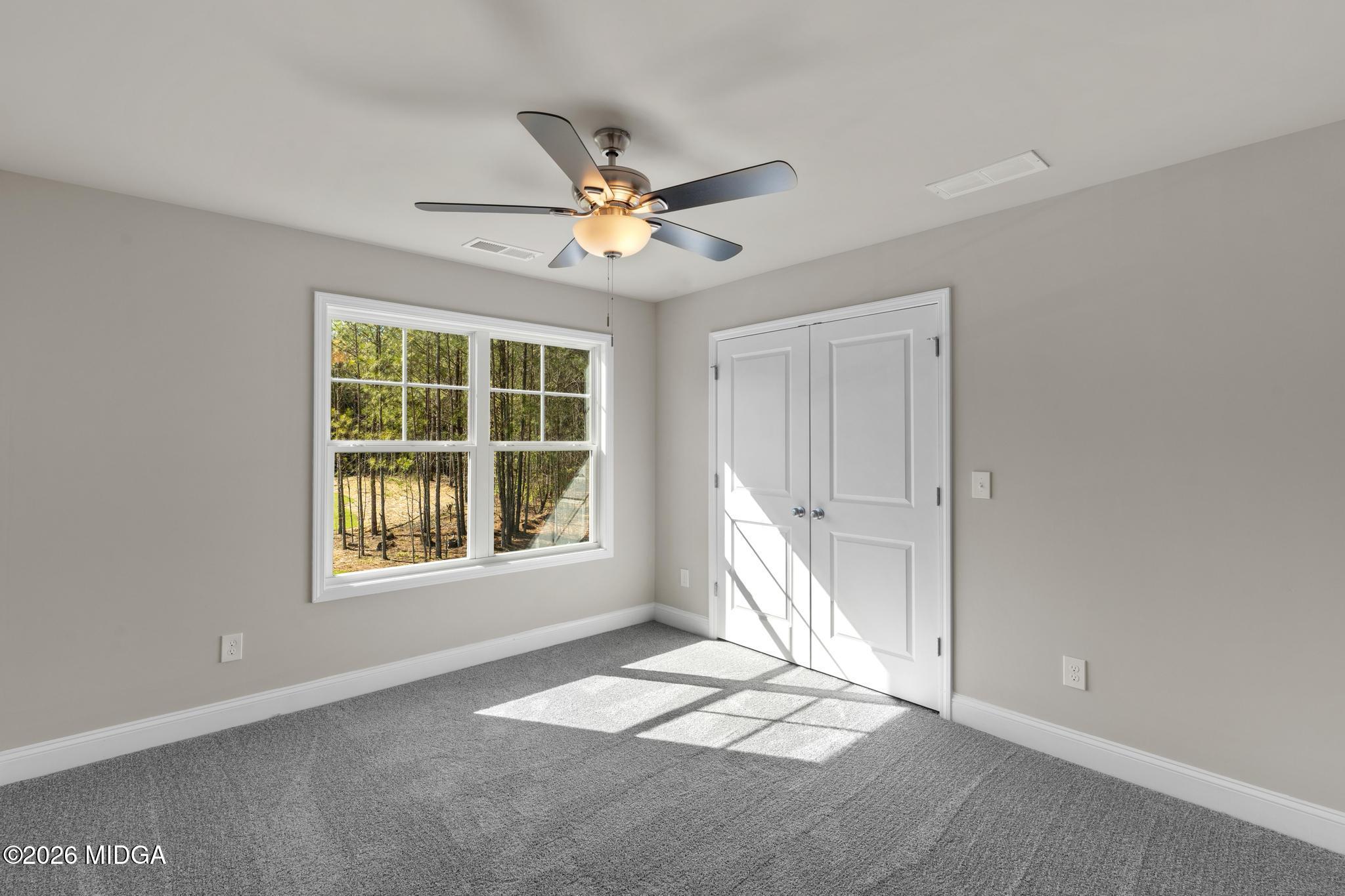 220 Welsh Trail Macon, GA 31216 - Photo 23 of 30 an empty room with windows and fan chandelier