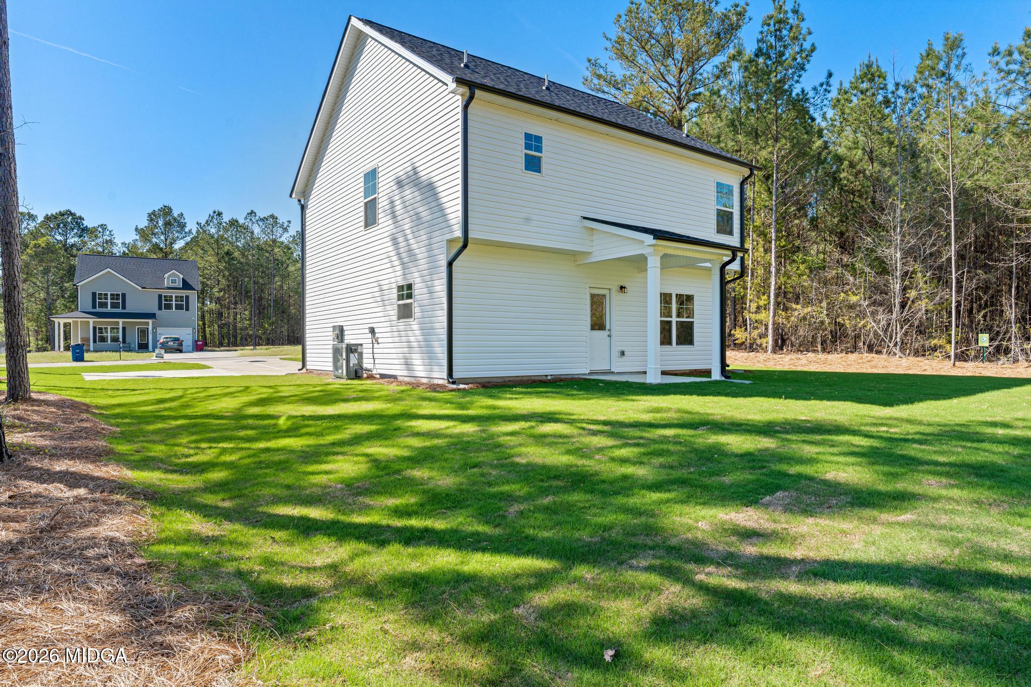 220 Welsh Trail Macon, GA 31216 - Photo 8 of 30 a view of a white house with a big yard and potted plants