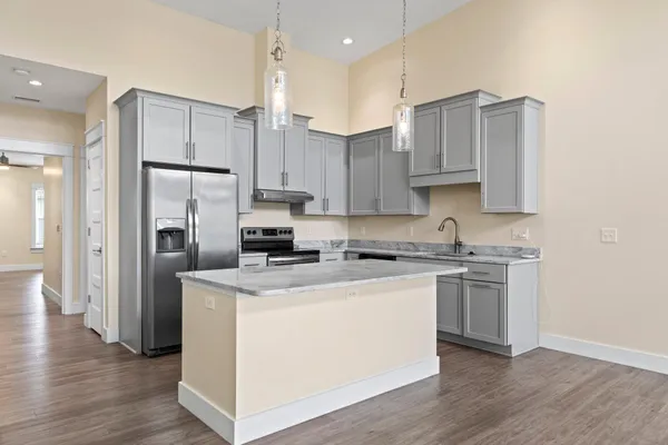 a kitchen with appliances cabinets and a wooden floor