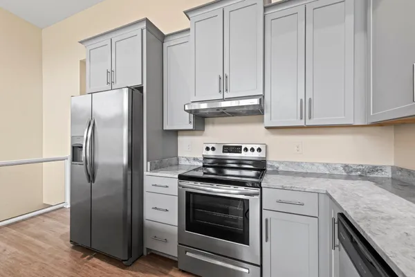 a kitchen with stainless steel appliances granite countertop a sink a stove and a refrigerator