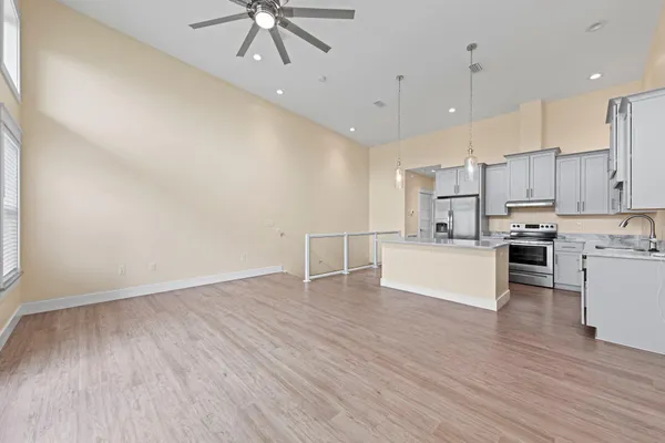 a view of an empty room with a window and wooden floor