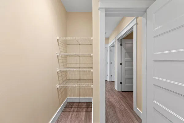 an empty room with wooden floor cabinet and windows