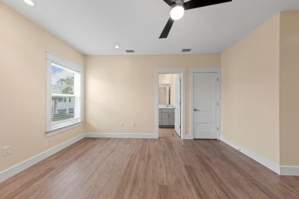 a bathroom with a double vanity sink toilet mirror and windows