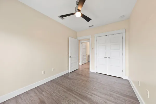 an empty room with wooden floor and windows