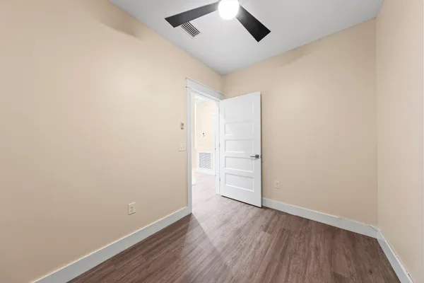 a view of a room with wooden floor and white walls