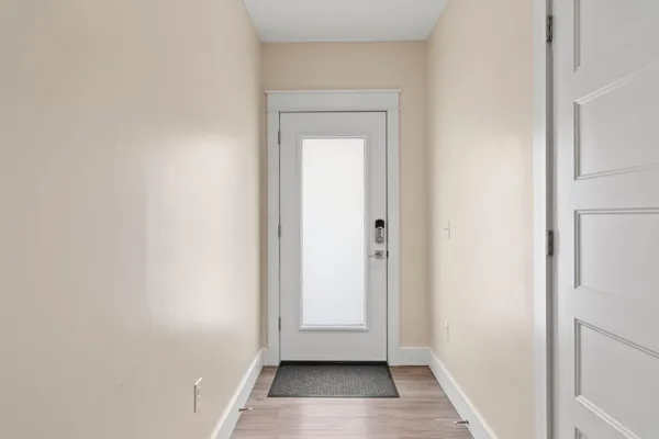 a view of a hallway with wooden floor and entryway