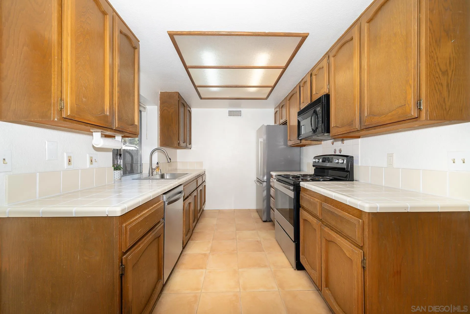 10134 Princess Joann Road Santee, CA 92071 - Photo 11 of 29 a kitchen with stainless steel appliances granite countertop a sink a stove and a refrigerator