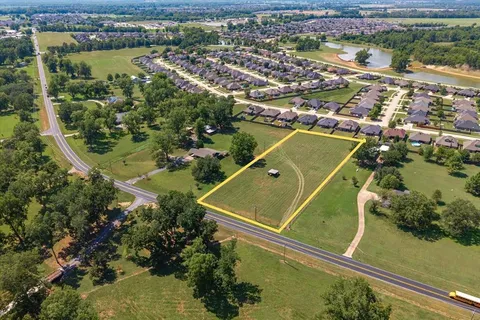 an aerial view of a residential houses with outdoor space and river