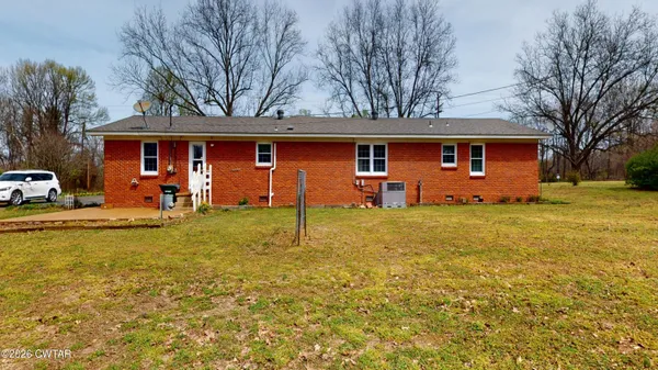 a front view of house with yard and trees around