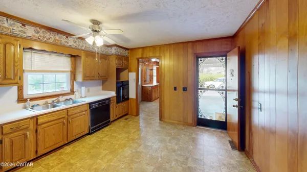 a large kitchen with a window and stainless steel appliances