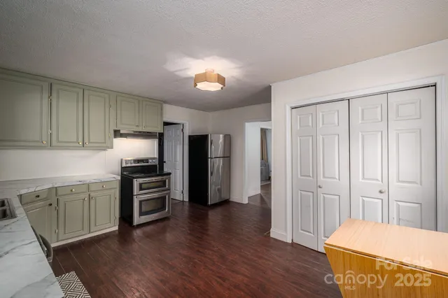 a kitchen with stainless steel appliances a refrigerator and microwave