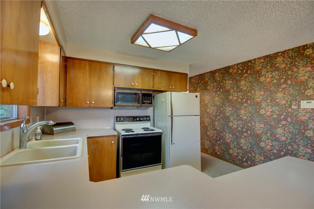 21889 Little Mountain Road Mount Vernon, WA 98274 - Photo 11 of 31 a kitchen with stainless steel appliances a refrigerator a sink a stove and white cabinets