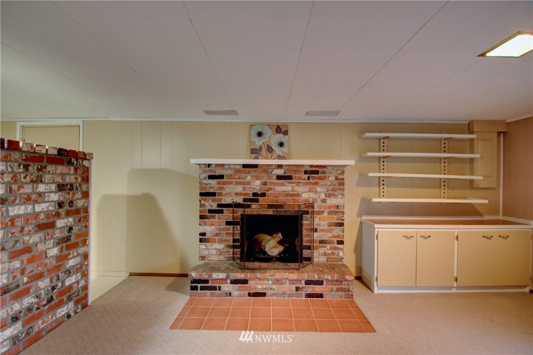 21889 Little Mountain Road Mount Vernon, WA 98274 - Photo 22 of 31 a living room with a fireplace and a walk in closet with wooden floor