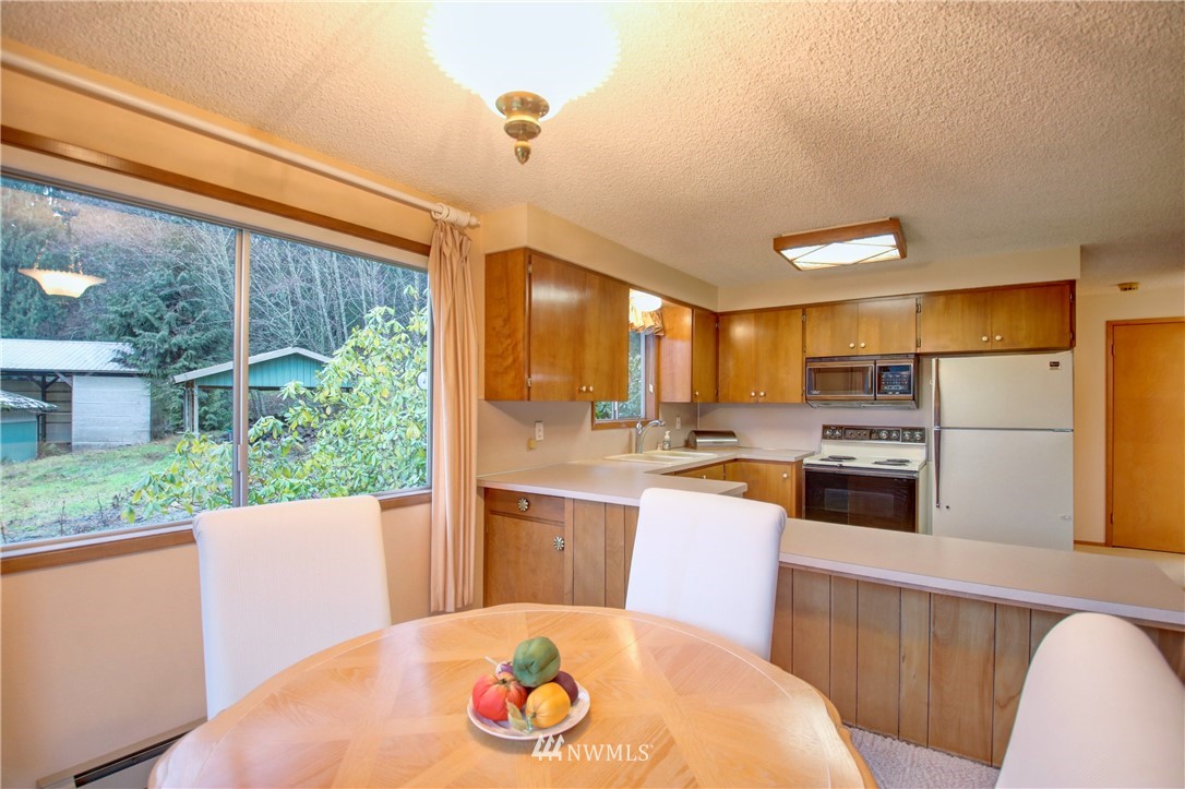 21889 Little Mountain Road Mount Vernon, WA 98274 - Photo 10 of 31 a kitchen with a refrigerator a stove a sink dishwasher with a dining table and chairs