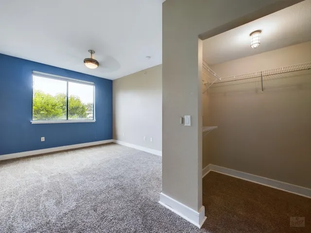an empty room with windows and closet