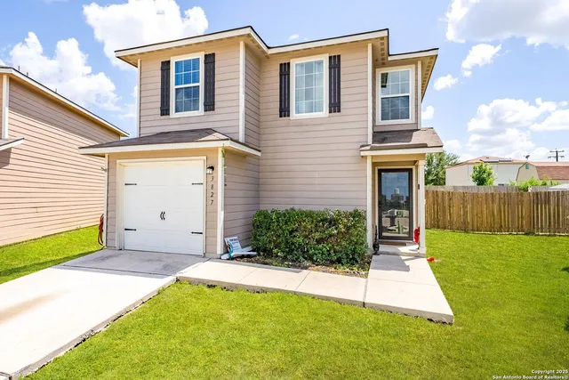 a backyard of a house with plants and wooden fence