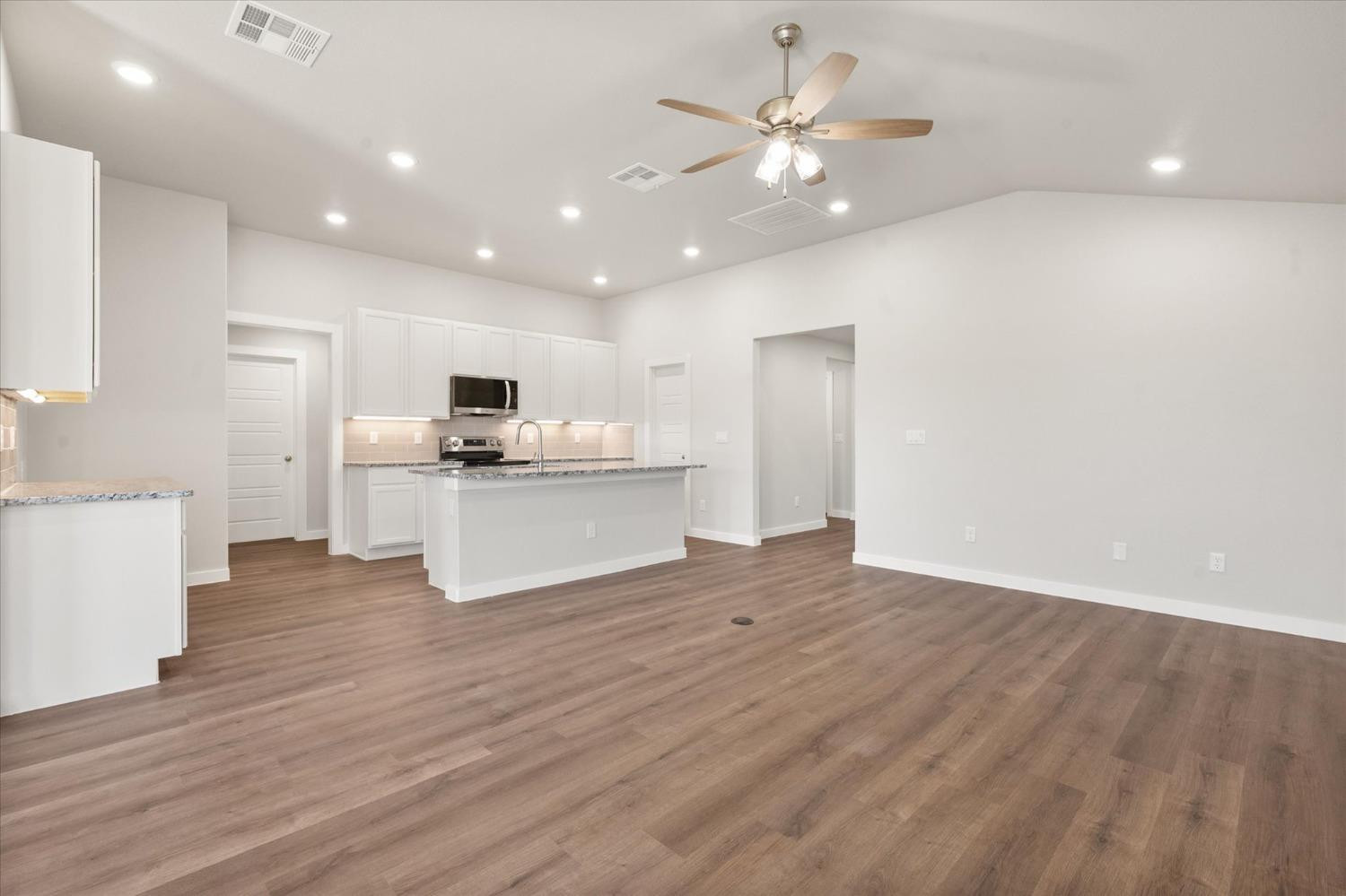 7007 9th Street Lubbock, TX 79416 - Photo 5 of 22 a view of a kitchen with a sink and dishwasher a refrigerator with wooden floor