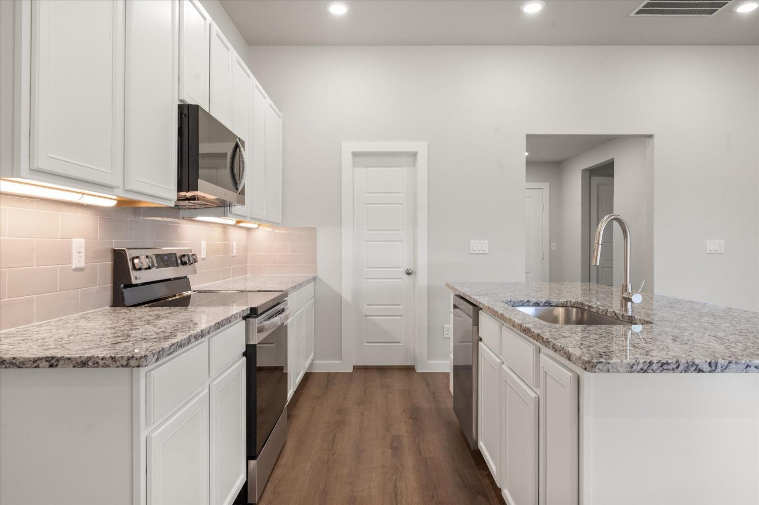 7007 9th Street Lubbock, TX 79416 - Photo 10 of 22 a kitchen with stainless steel appliances granite countertop a sink stove and cabinets