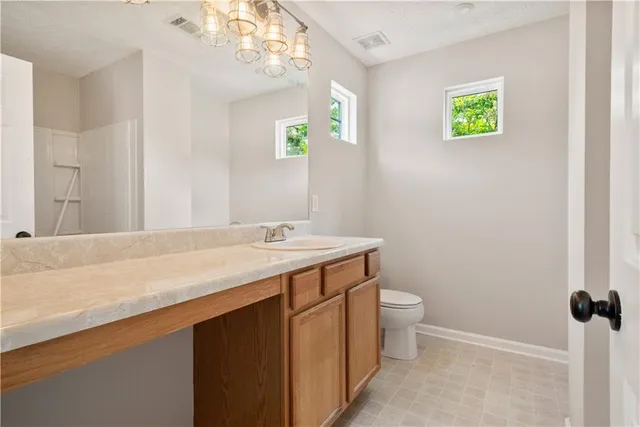 a bathroom with a sink a toilet and a mirror