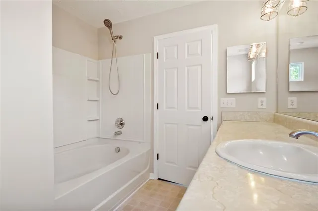 a bathroom with a tub a sink and a shower