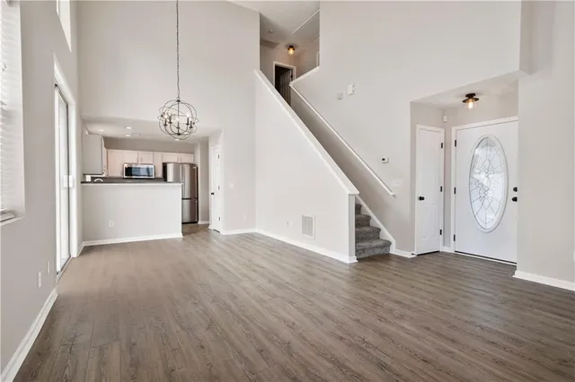 a view of a hallway with wooden floor and staircase
