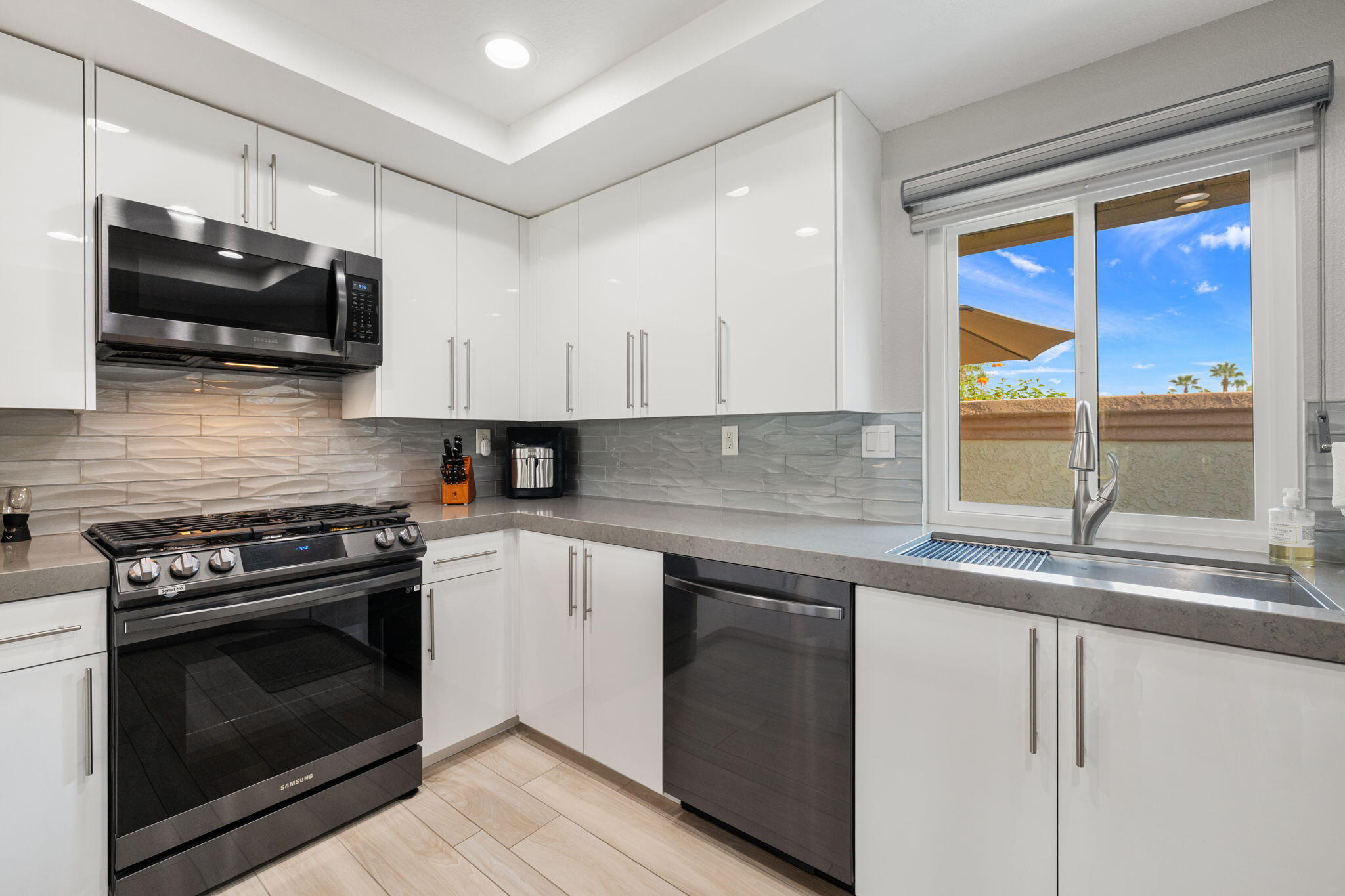42831 Scirocco Road Palm Desert, CA 92211 - Photo 11 of 32 a kitchen with stainless steel appliances granite countertop a sink and a stove